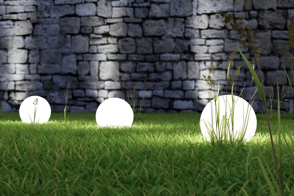 glowing light orbs on grass with dark grey wall background